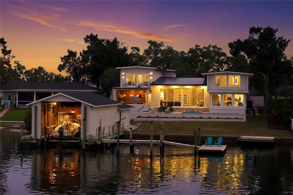 A two-story house with a gray exterior, a dark garage door, and a palm tree — 915 BAYSHORE DRIVE, TARPON SPRINGS, FL