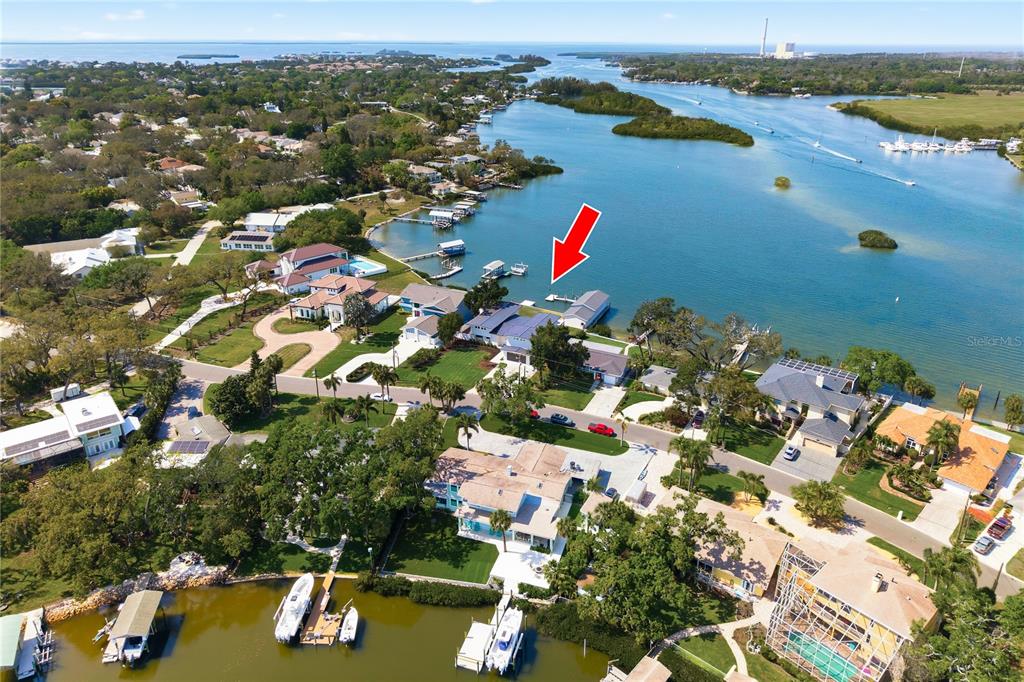 A two-story modern house with a white exterior, metal roof, and attached garage — 915 BAYSHORE DRIVE, TARPON SPRINGS, FL