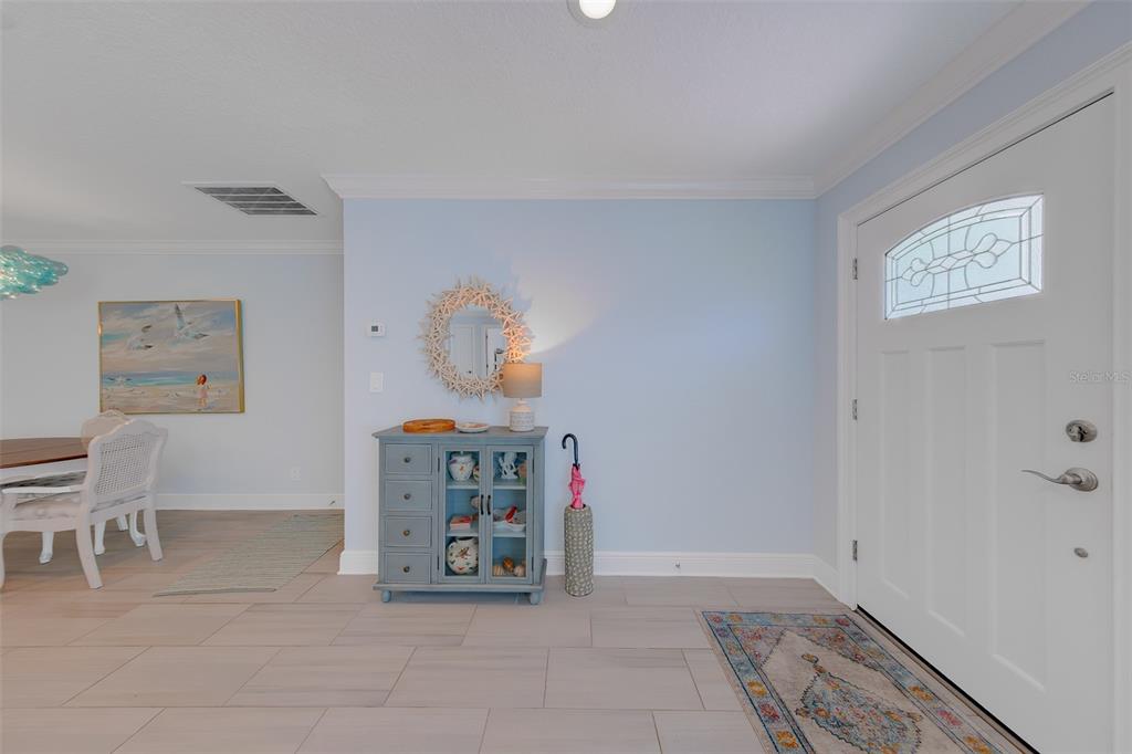 A kitchen island with a light countertop sits in front of a dining area — 196 OVERBROOK DRIVE E, LARGO, FL