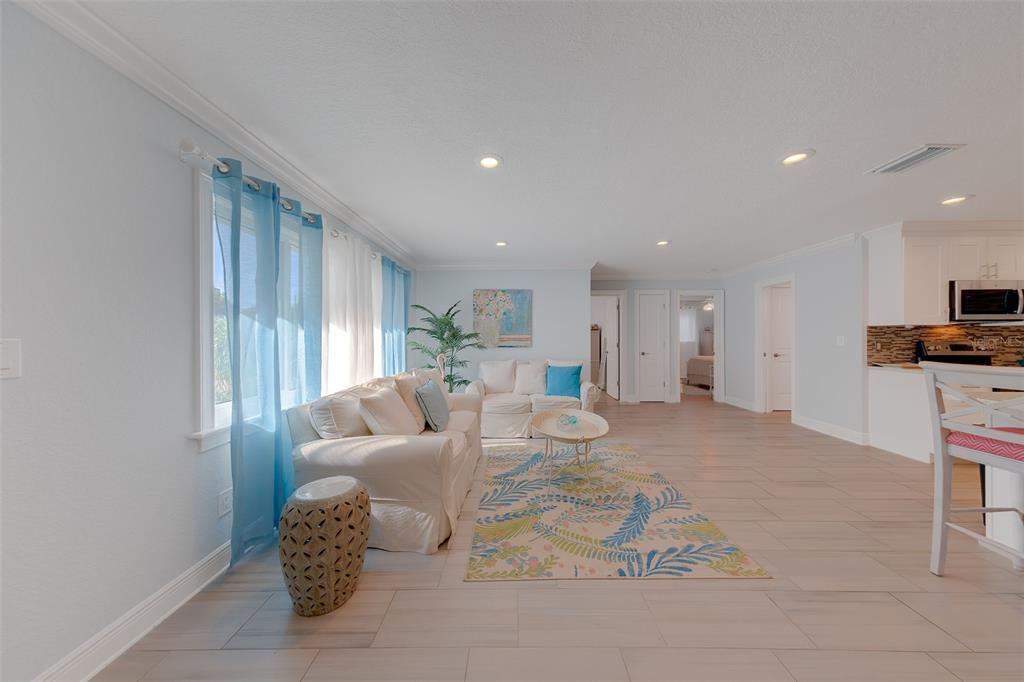 A kitchen with white cabinets and a center island opens into a dining area — 196 OVERBROOK DRIVE E, LARGO, FL