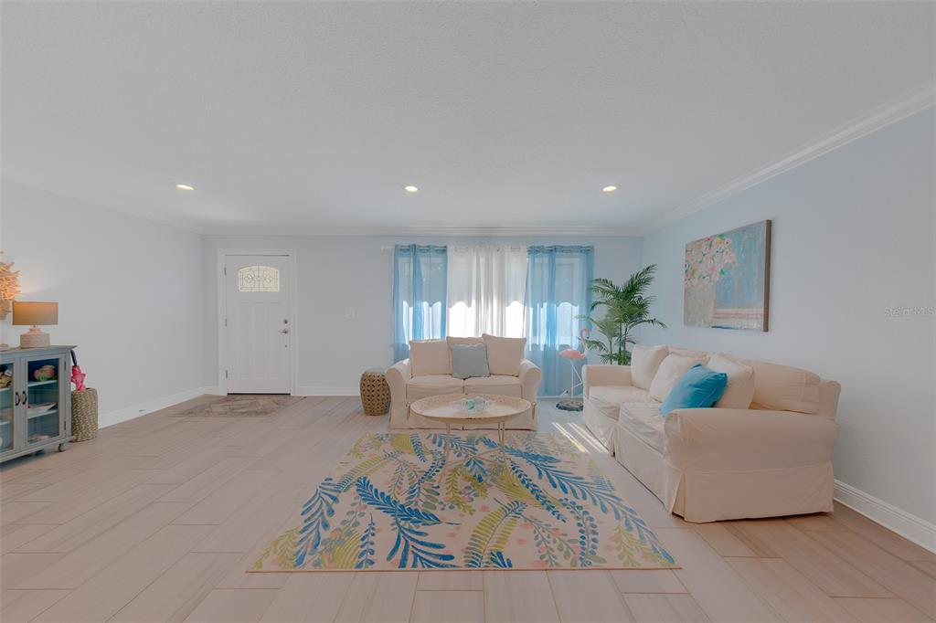 A kitchen features white cabinetry, stainless steel appliances, and a light-colored quartz countertop — 196 OVERBROOK DRIVE E, LARGO, FL