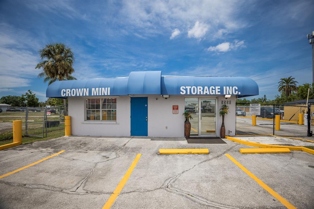 The exterior of a small, white commercial building with a blue awning and parking spaces — 5550 15TH STREET E, BRADENTON, FL