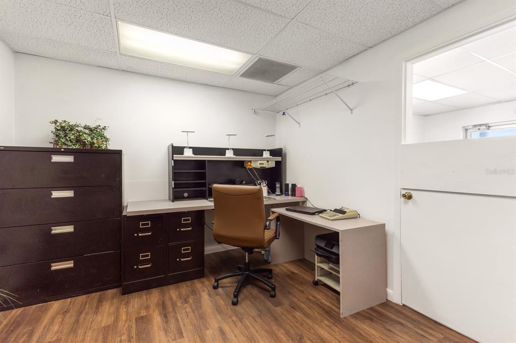 An office space features a dark wood desk, a brown chair, and a tall filing cabinet — 5550 15TH STREET E, BRADENTON, FL