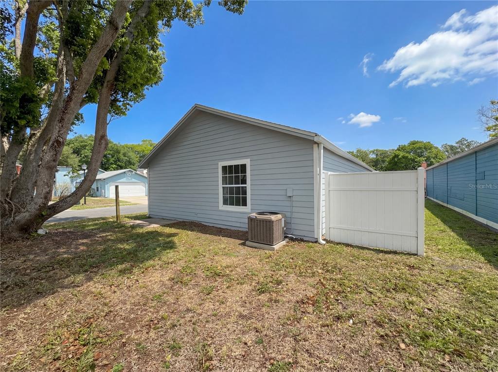 The exterior of a light blue house features a window, an HVAC unit, and fencing — 2000 PLAINFIELD DRIVE, ORLANDO, FL
