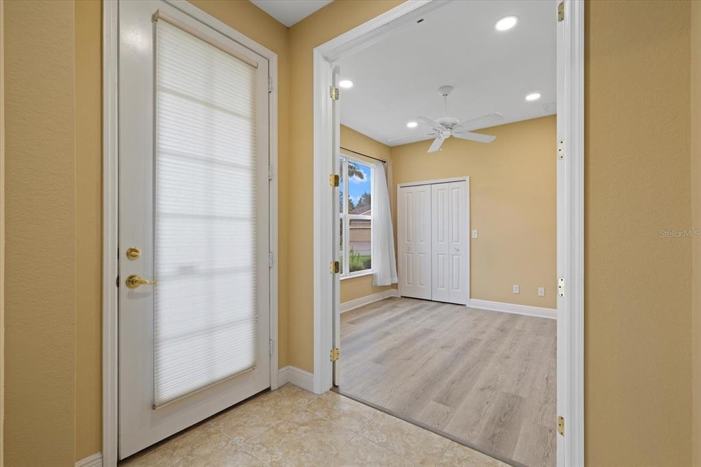 A tiled entryway leads into a room with light wood-look flooring and a ceiling fan — 4331 TURNBERRY CIRCLE, NORTH PORT, FL