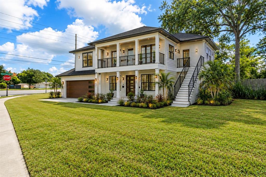 A two-story house with a white exterior, a wooden garage door, and an outdoor staircase — SEMINOLA BOULEVARD, CASSELBERRY, FL