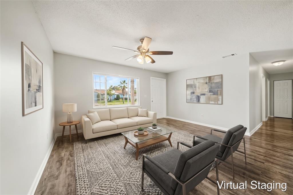 An empty living room features light gray walls, wood-look flooring, and a ceiling fan — 4814 BLARNEY DRIVE, ORLANDO, FL