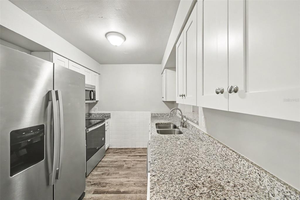 An empty bedroom features light gray paneled walls, wood-look flooring, and a ceiling fan — 4814 BLARNEY DRIVE, ORLANDO, FL