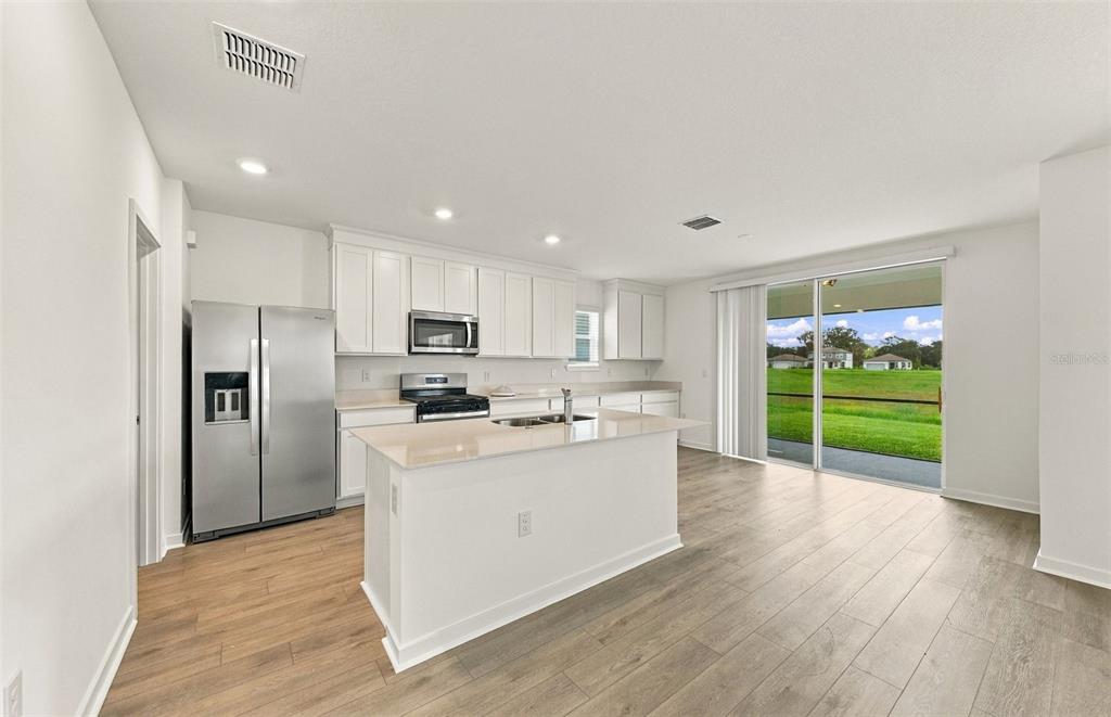A mudroom area features a black storage bench with shelving, a mirror, and a door — 9185 NEWMONS PLACE, WILDWOOD, FL