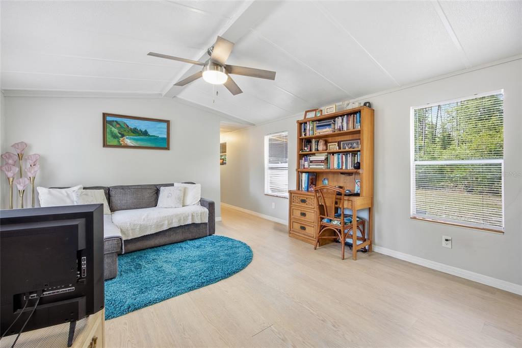 A small dining area features a rattan table and chairs against a blue accent wall — 2412 NW 116TH PLACE, GAINESVILLE, FL