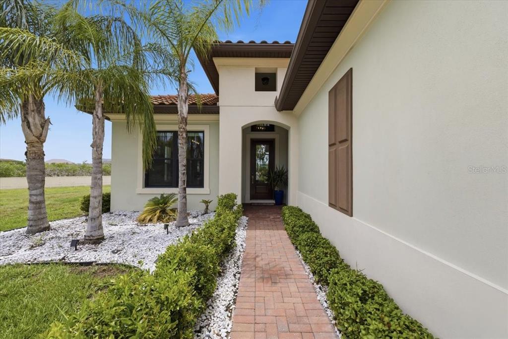 An entryway features a blue geometric accent wall, light wood-look tile flooring, and a door — 2317 5TH STREET E, PALMETTO, FL