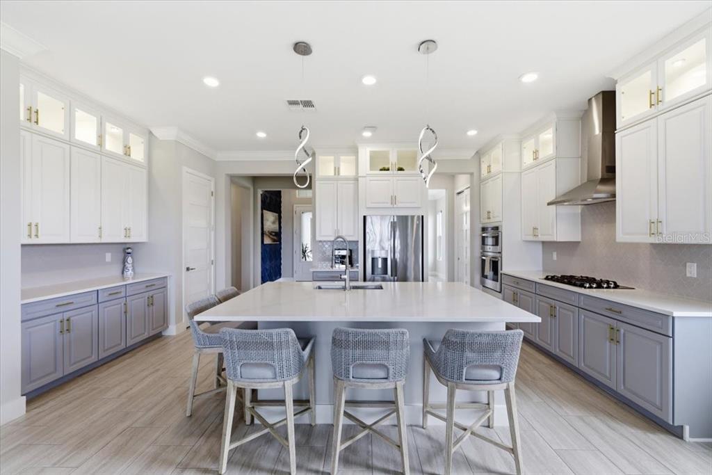 An empty dining room features light gray walls, wood-look tile flooring, and a rectangular chandelier — 2317 5TH STREET E, PALMETTO, FL