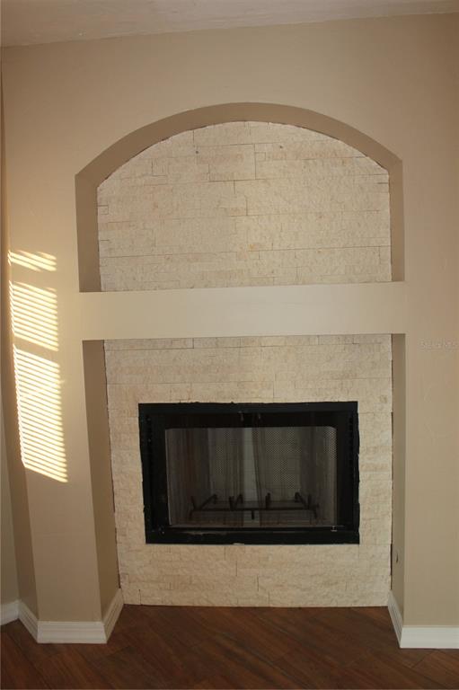 A fireplace with a stone facade and an arched alcove sits against a beige wall — 9082 ACORN BOULEVARD, PUNTA GORDA, FL