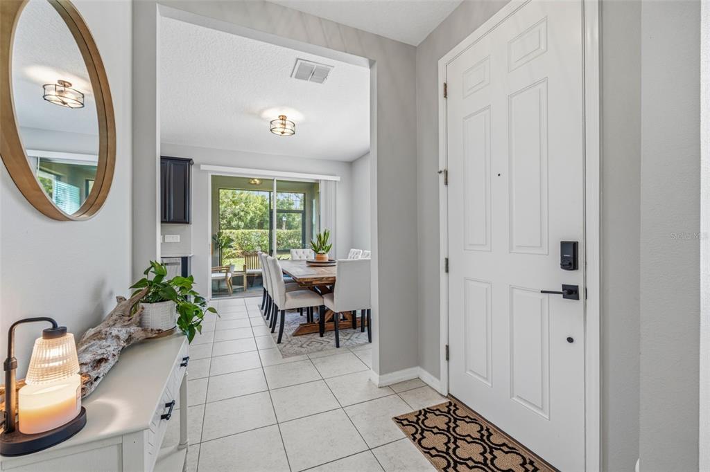An entryway with a white door leads into a dining area with tile flooring — 6380 CAMINO DRIVE, APOLLO BEACH, FL