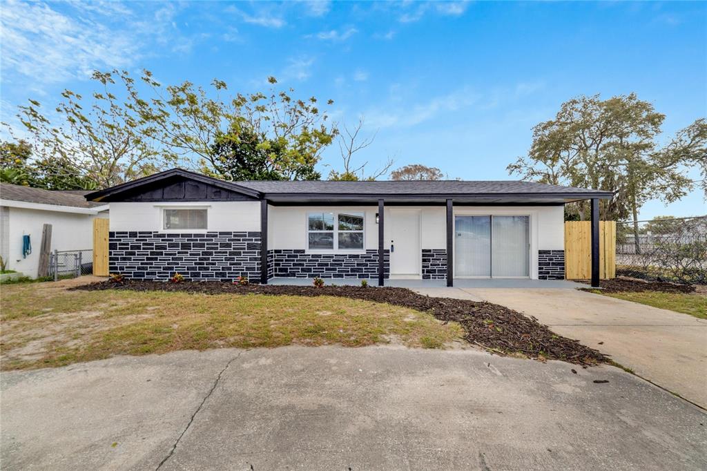 A single-story house with a black and white exterior and a curved concrete driveway — 4012 VALENCIA DRIVE, NEW PORT RICHEY, FL