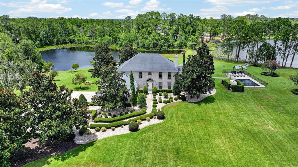 A two-story brick house with a large lawn and mature trees at sunset — 350 FOX HOLLOW FARMS ROAD, PIERSON, FL