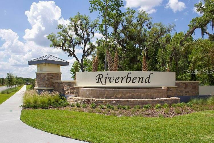 A stone and stucco monument sign for Riverbend stands in a landscaped residential entrance area — 3940 SILVERSTREAM TERRACE, SANFORD, FL