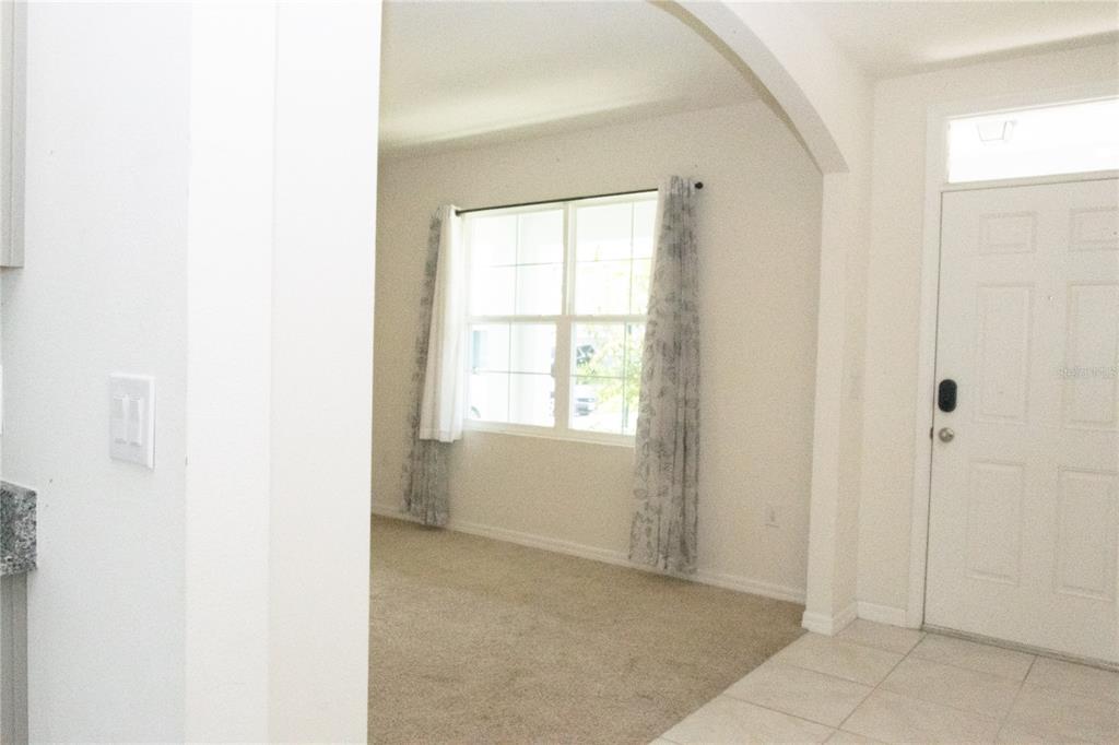 A carpeted room with a window and curtains is visible through an arched entryway — 3940 SILVERSTREAM TERRACE, SANFORD, FL