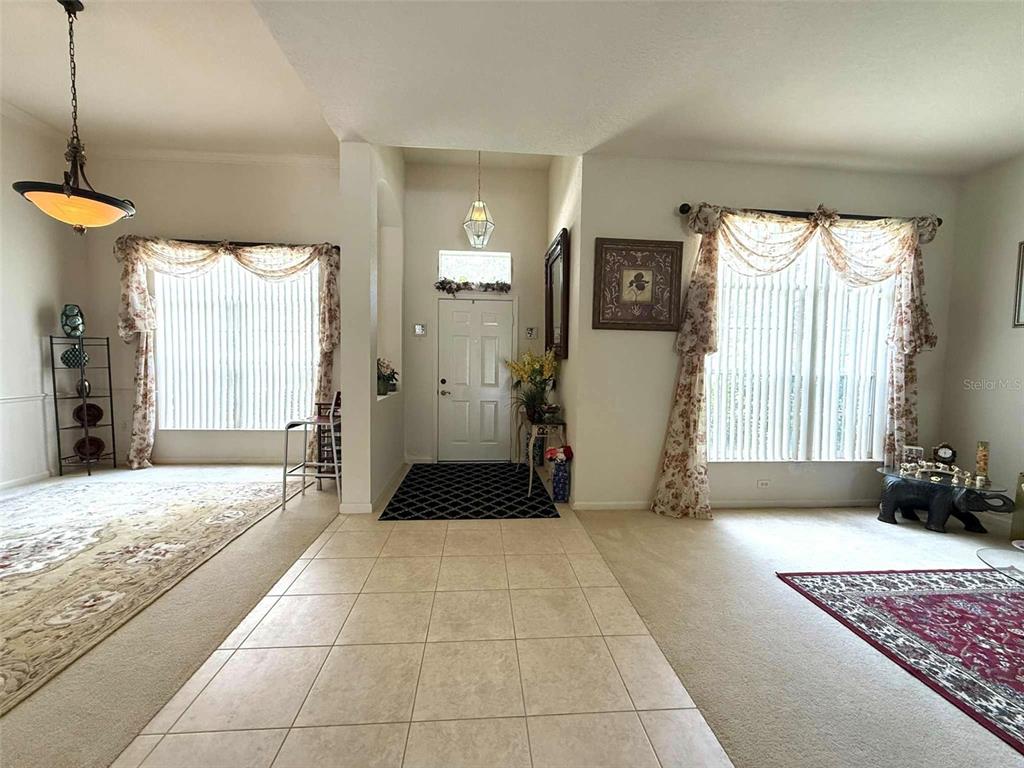 A tiled entryway leads to a front door flanked by two carpeted living areas — 3539 MAPLE RIDGE LOOP, KISSIMMEE, FL
