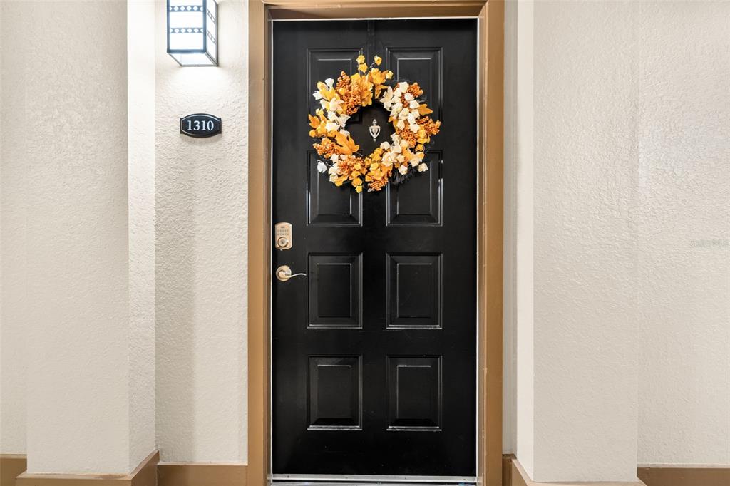 A black front door with a silver knocker and a room number sign 1310 — 4221 W SPRUCE STREET UNIT 1310, TAMPA, FL