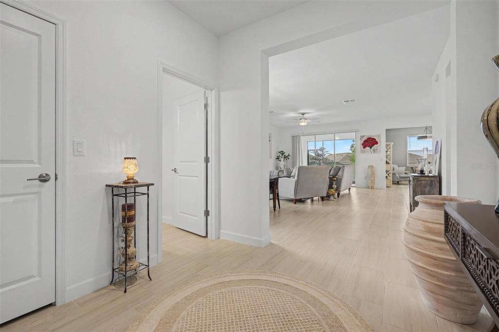 A bright entryway with light tile flooring leads into an open-concept living area — 10499 GABLE DIG LOOP, SAN ANTONIO, FL