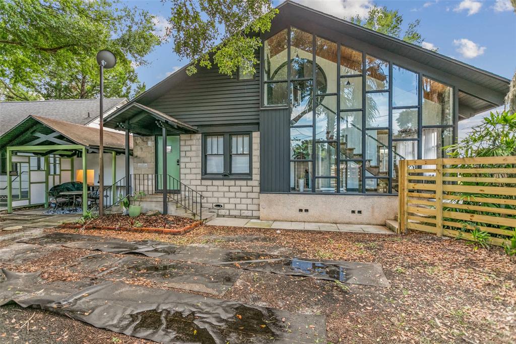 A modern house exterior features a large glass wall, dark siding, and a stone base — 10 PACIFIC STREET, ST AUGUSTINE, FL