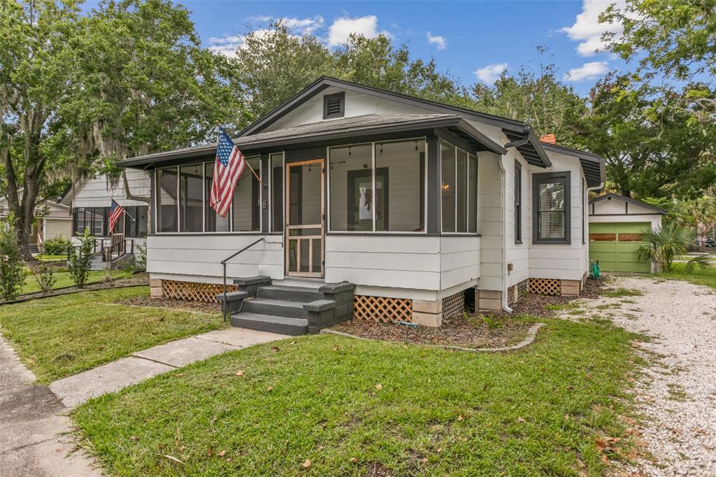A white bungalow with a screened front porch, dark trim, and a detached garage — 10 PACIFIC STREET, ST AUGUSTINE, FL