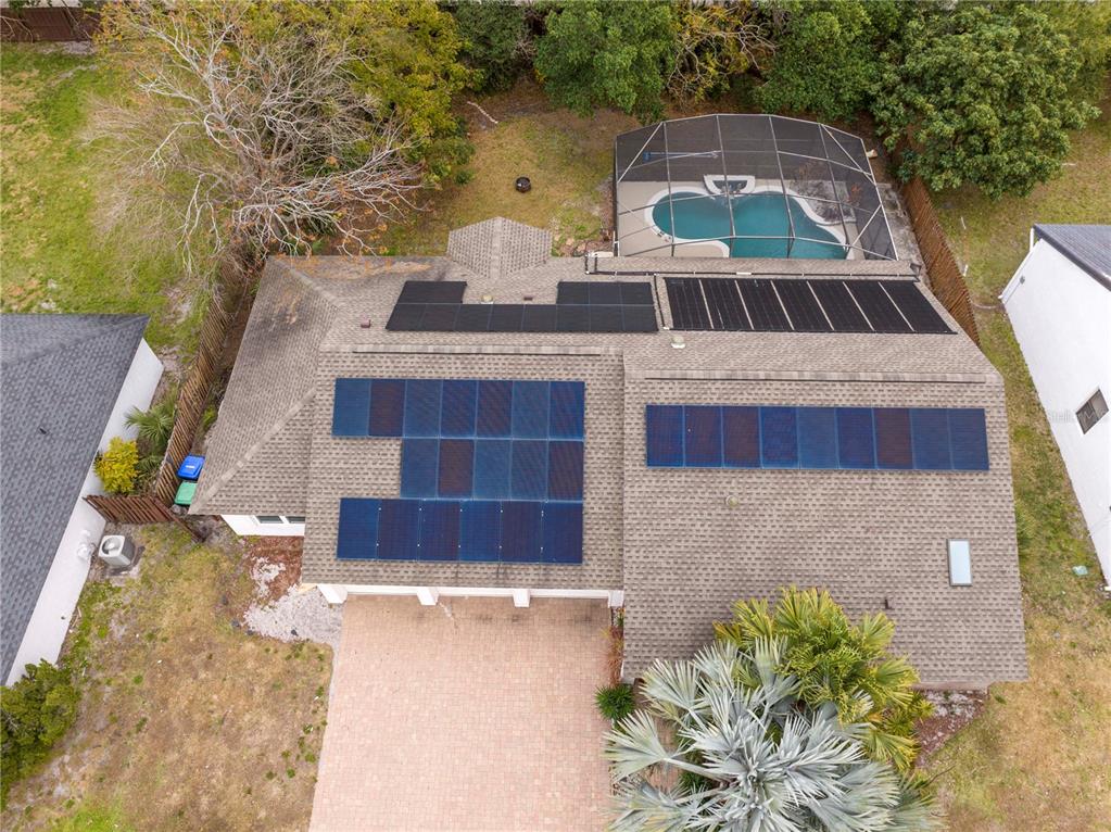 An aerial view shows a house roof with solar panels and a pool with a screen — 6013 CRYSTAL VIEW DRIVE, ORLANDO, FL
