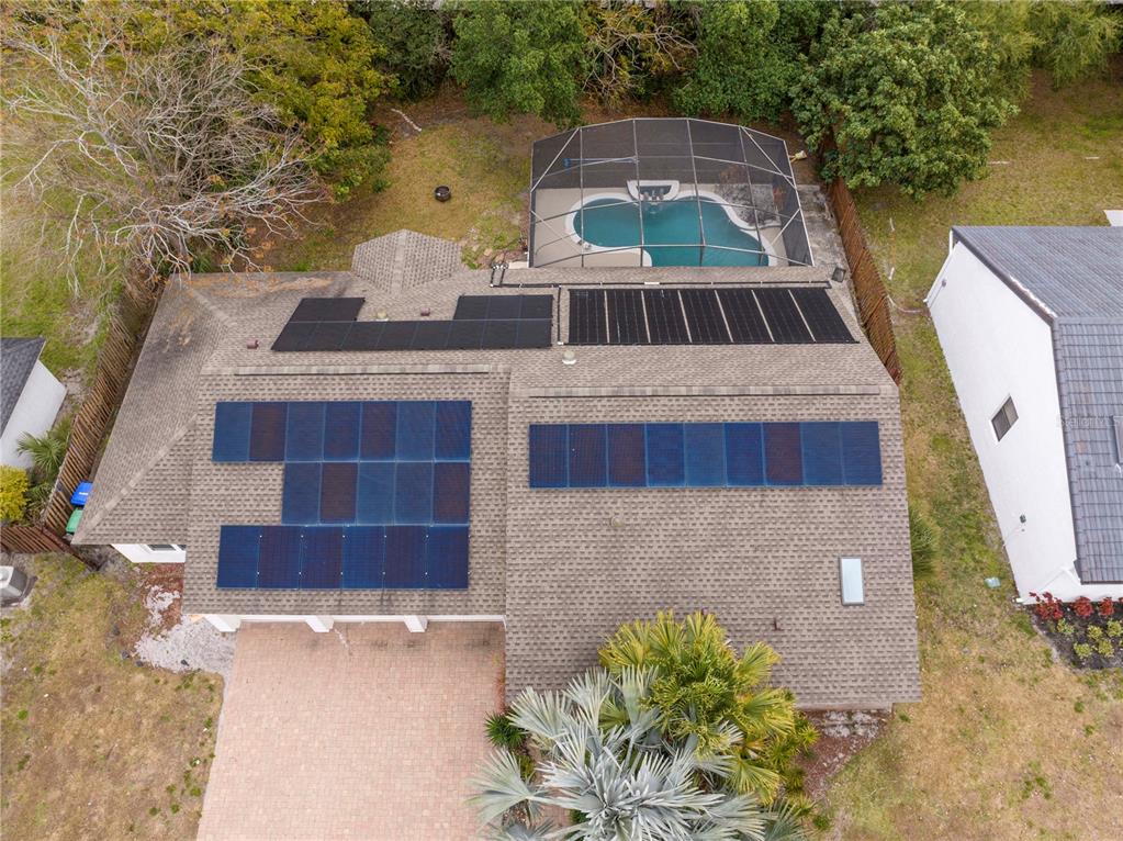 An aerial view shows a house with solar panels and a screened-in swimming pool — 6013 CRYSTAL VIEW DRIVE, ORLANDO, FL