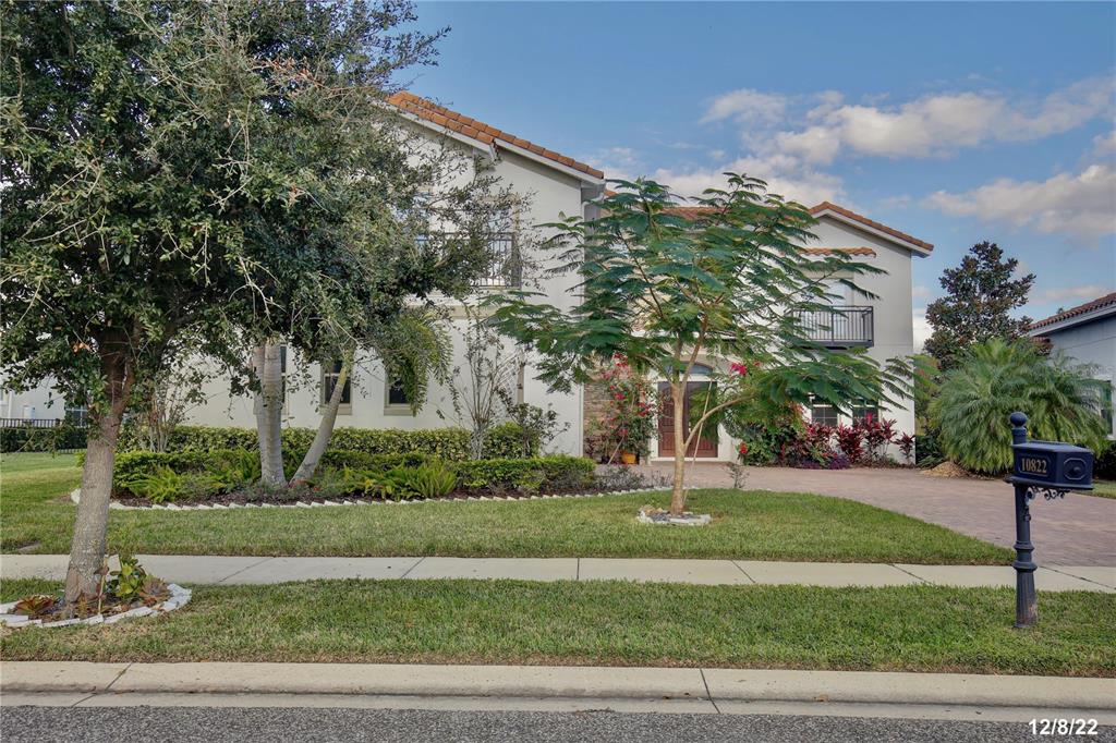 A two-story house with a stone facade, a paved driveway, and two garage doors — 10822 MOBBERLEY CIRCLE, ORLANDO, FL
