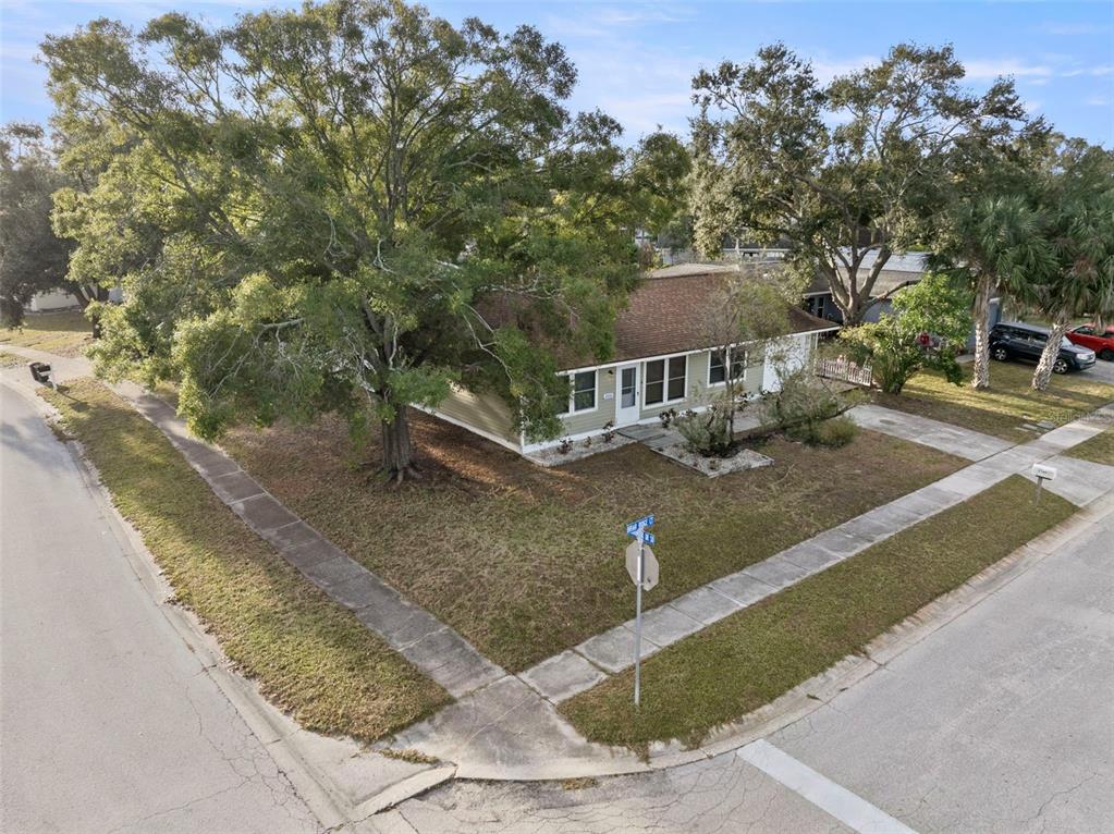 An exterior view of a single-story house on a corner lot with large shade trees — 6500 BRIAR RIDGE COURT N, PINELLAS PARK, FL