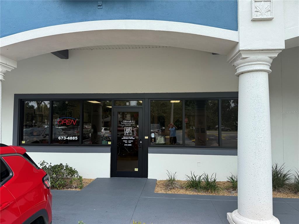 The exterior of a commercial storefront features a glass door and windows with signage — 500 W GRANADA BOULEVARD UNIT 3, ORMOND BEACH, FL