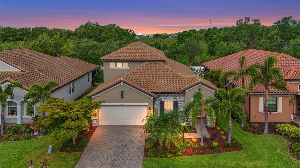 An aerial view of a single-story house with a tiled roof and a paved driveway — 2745 62ND AVENUE E, ELLENTON, FL