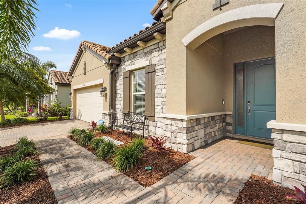 A paved walkway leads to the front entrance of a house with stone veneer siding — 2745 62ND AVENUE E, ELLENTON, FL