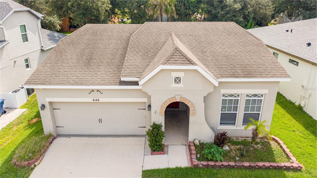 An aerial view of a single-story house with a tan stucco exterior and shingled roof — 646 ARBOR POINTE AVENUE, MINNEOLA, FL