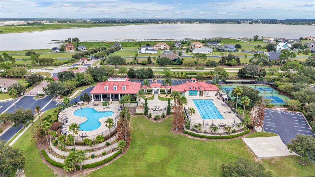 An aerial view shows a community clubhouse with two swimming pools, tennis courts, and parking — 534 BLUE FLAG DRIVE, AUBURNDALE, FL