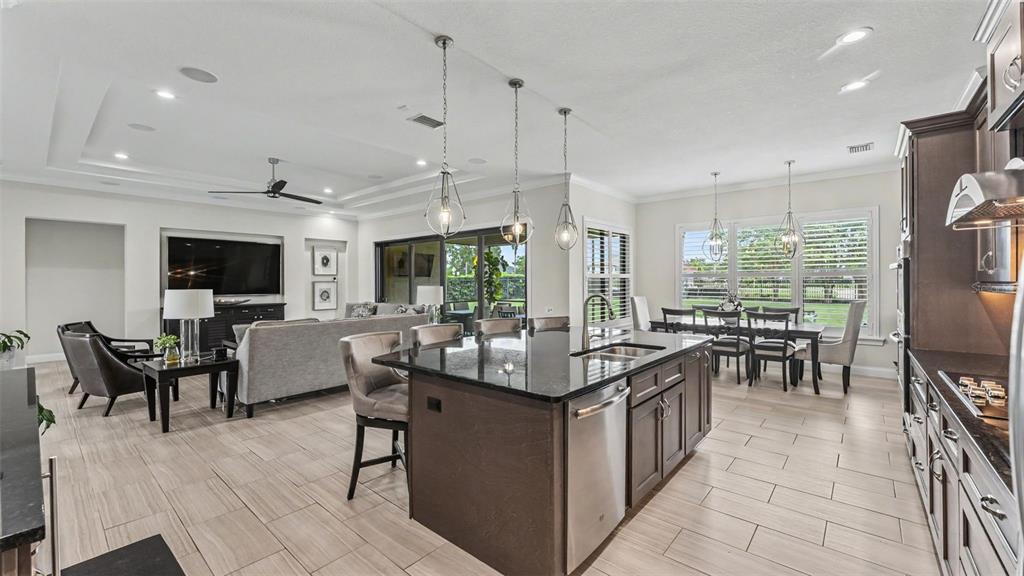 A two-story suburban house with a tiled roof, arched entryway, and a three-car garage — 534 BLUE FLAG DRIVE, AUBURNDALE, FL