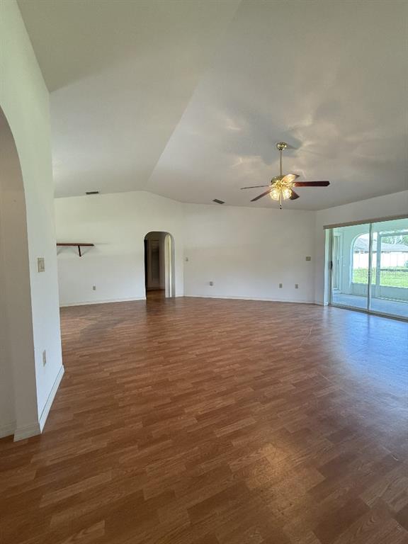 A spacious living room features wood-look flooring, a vaulted ceiling, and a ceiling fan — 64 NORMAN STREET, PORT CHARLOTTE, FL