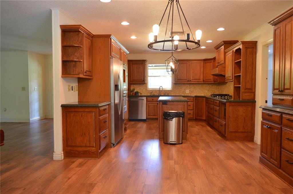 A living room features a large sectional sofa, a brick fireplace, and a television console — 308 N SALISBURY AVENUE, DELAND, FL