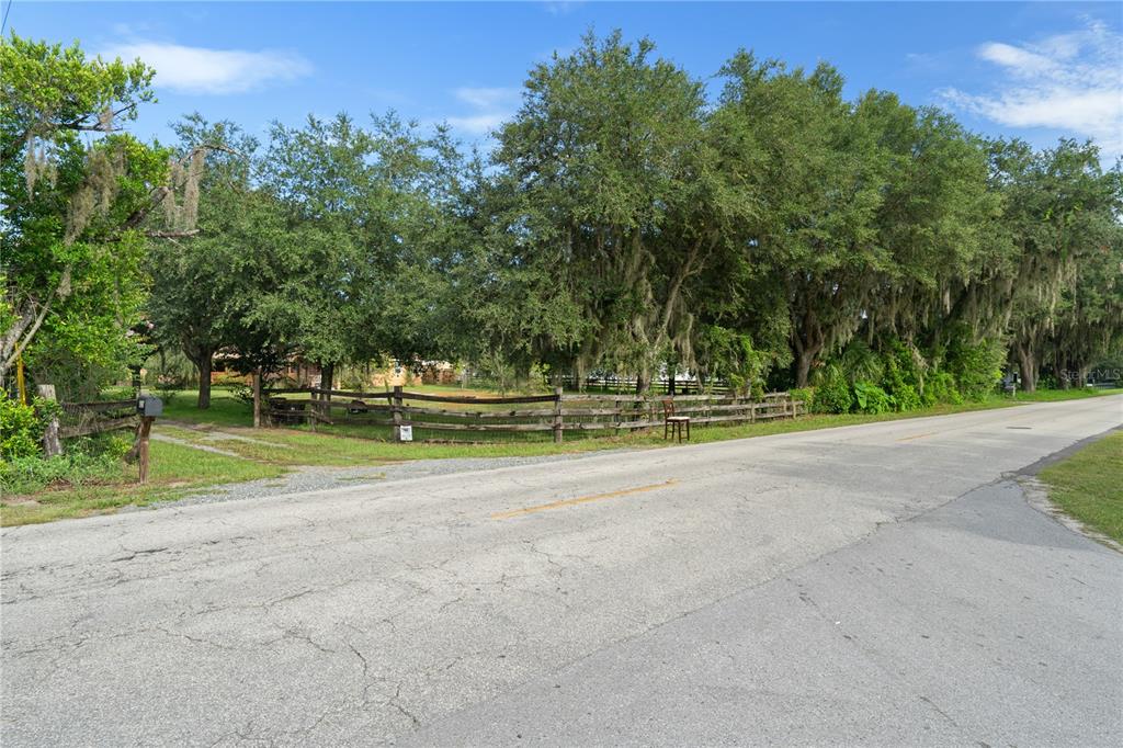 A rural road runs alongside a grassy lot enclosed by a wooden split-rail fence — 4235 ALLEN ROAD, ZEPHYRHILLS, FL