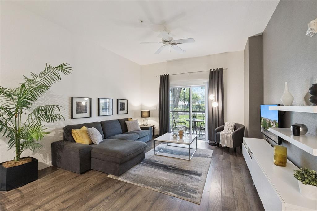 A living room features a gray sectional sofa, a coffee table, and a sliding glass door — 504 RUM RUN, DAVENPORT, FL