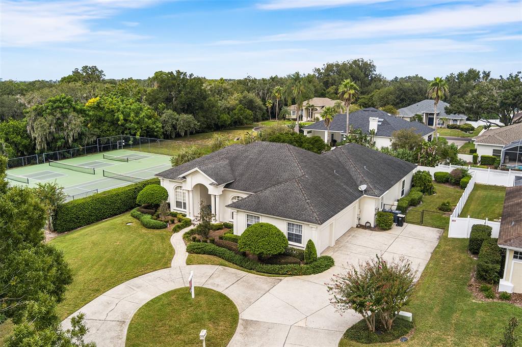 A single-story house with a stucco exterior and arched windows at sunset — 902 HANOVER WAY, LAKELAND, FL