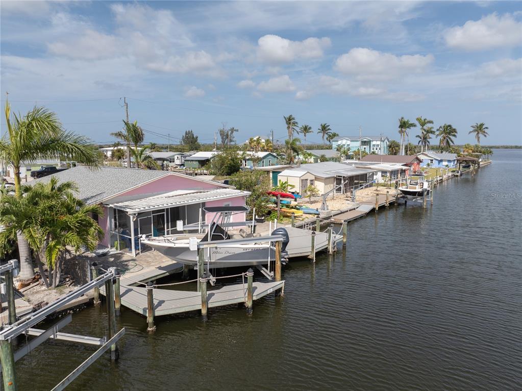 An aerial view of a waterfront house with a boat lift and a private dock — 11476 MAY STREET, MATLACHA, FL