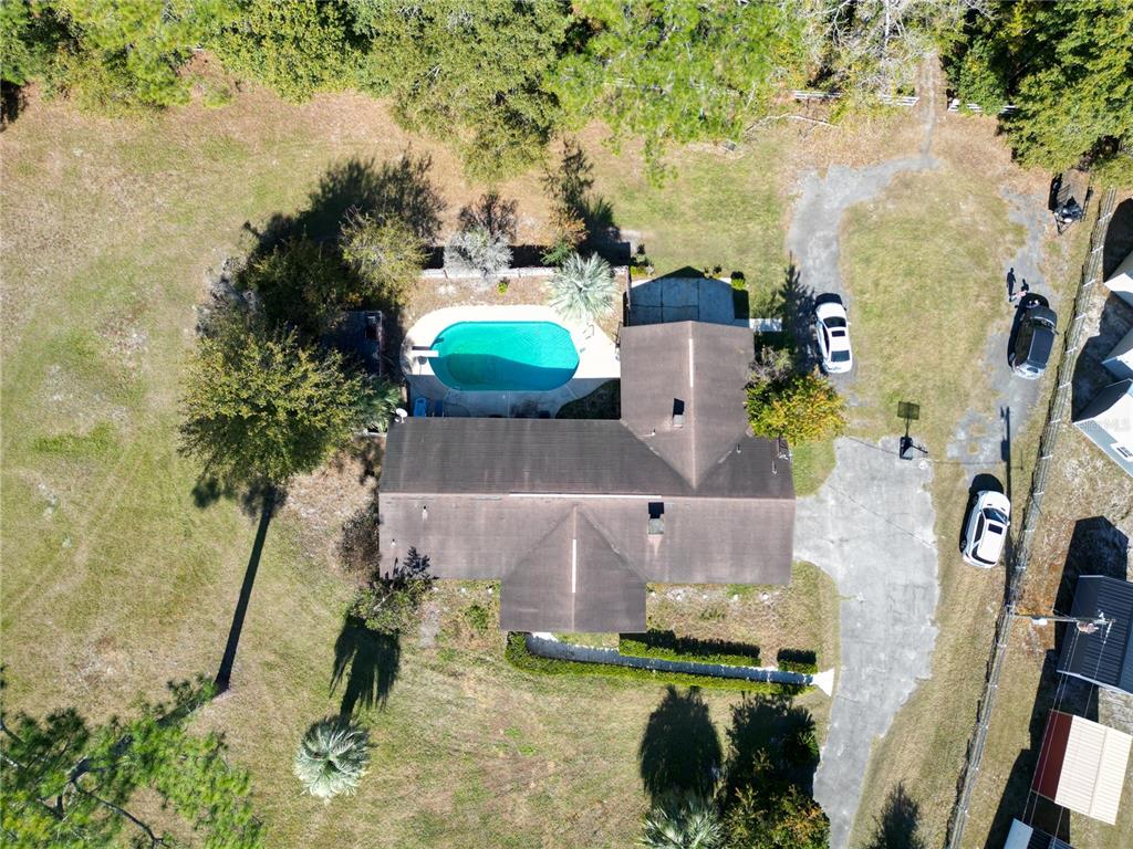An aerial view shows a house with a swimming pool and a driveway with cars — 12046 US-301, HAMPTON, FL