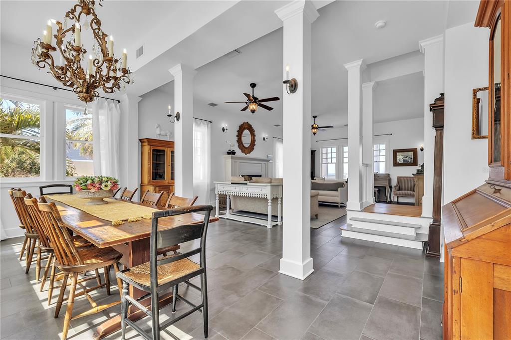 A dining area with a wooden table and chandelier opens into a living room space — 8241 MAIN STREET, BOKEELIA, FL