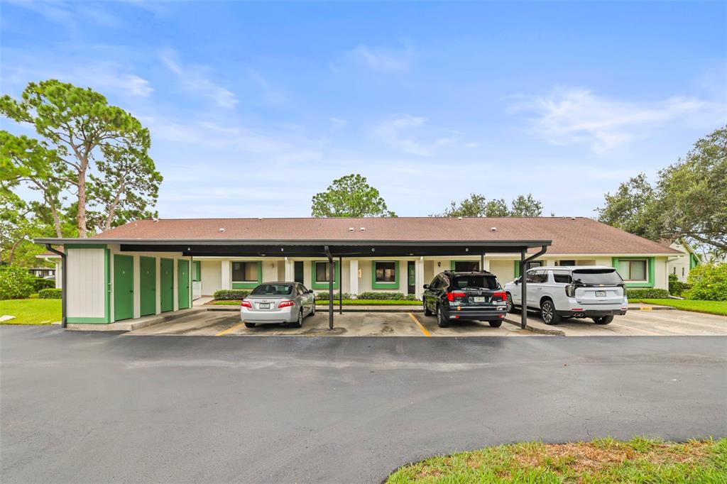 A single-story apartment building with a covered carport and three parked cars — 2556 ROYAL PINES CIRCLE UNIT 13-C, CLEARWATER, FL