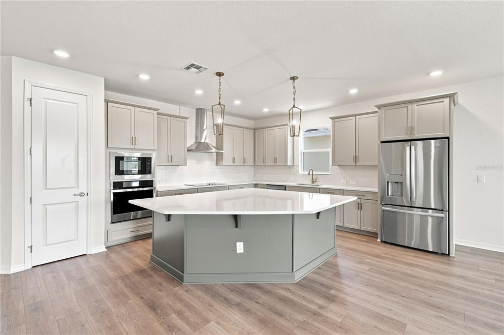 A newly constructed single-story house with a two-car garage and light blue siding — 5033 ORINOCO LANE, ST CLOUD, FL