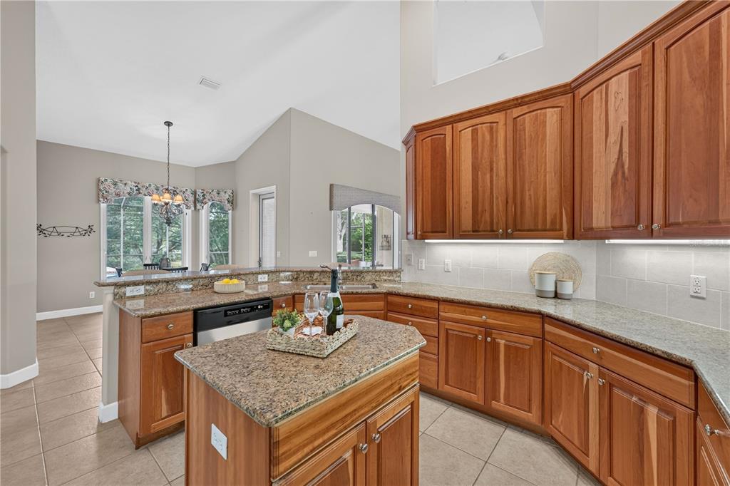 A kitchen with wood cabinets, granite countertops, a center island, and tile flooring — 2816 N PRESTWICK WAY, LECANTO, FL