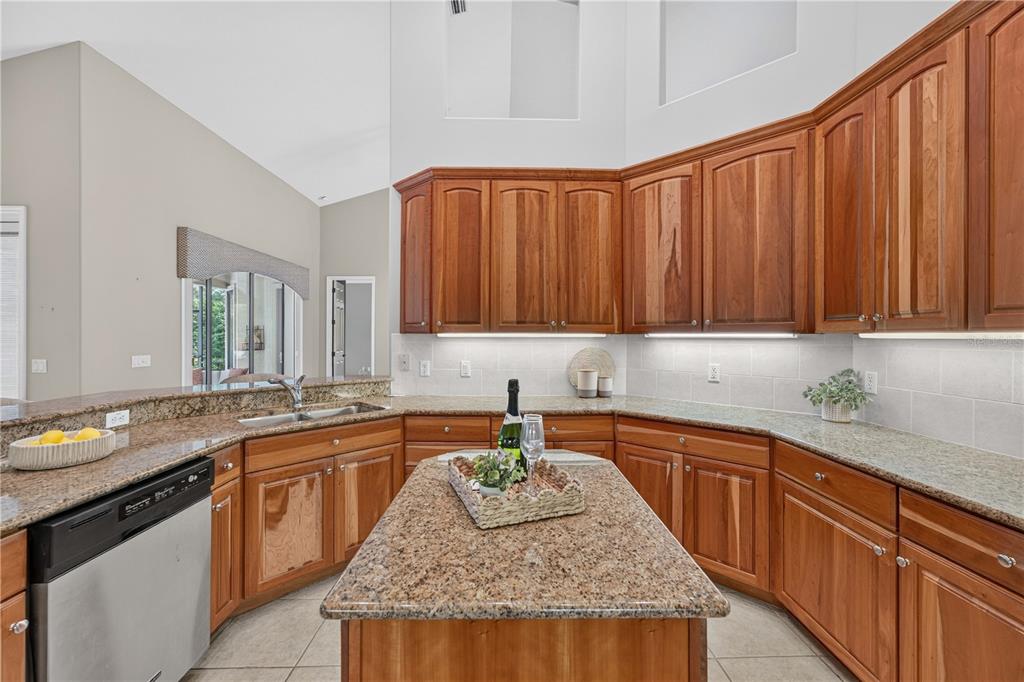 A kitchen features wood cabinets, granite countertops, a central island, and stainless steel appliances — 2816 N PRESTWICK WAY, LECANTO, FL