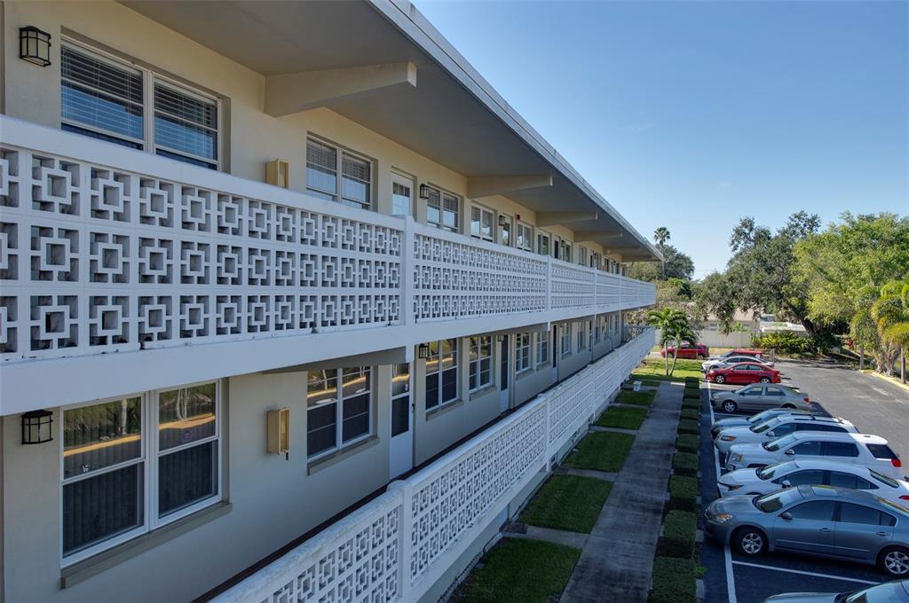 An exterior view of a two-story apartment building with decorative concrete block balcony railings — 8101 11TH STREET N UNIT 319, ST PETERSBURG, FL